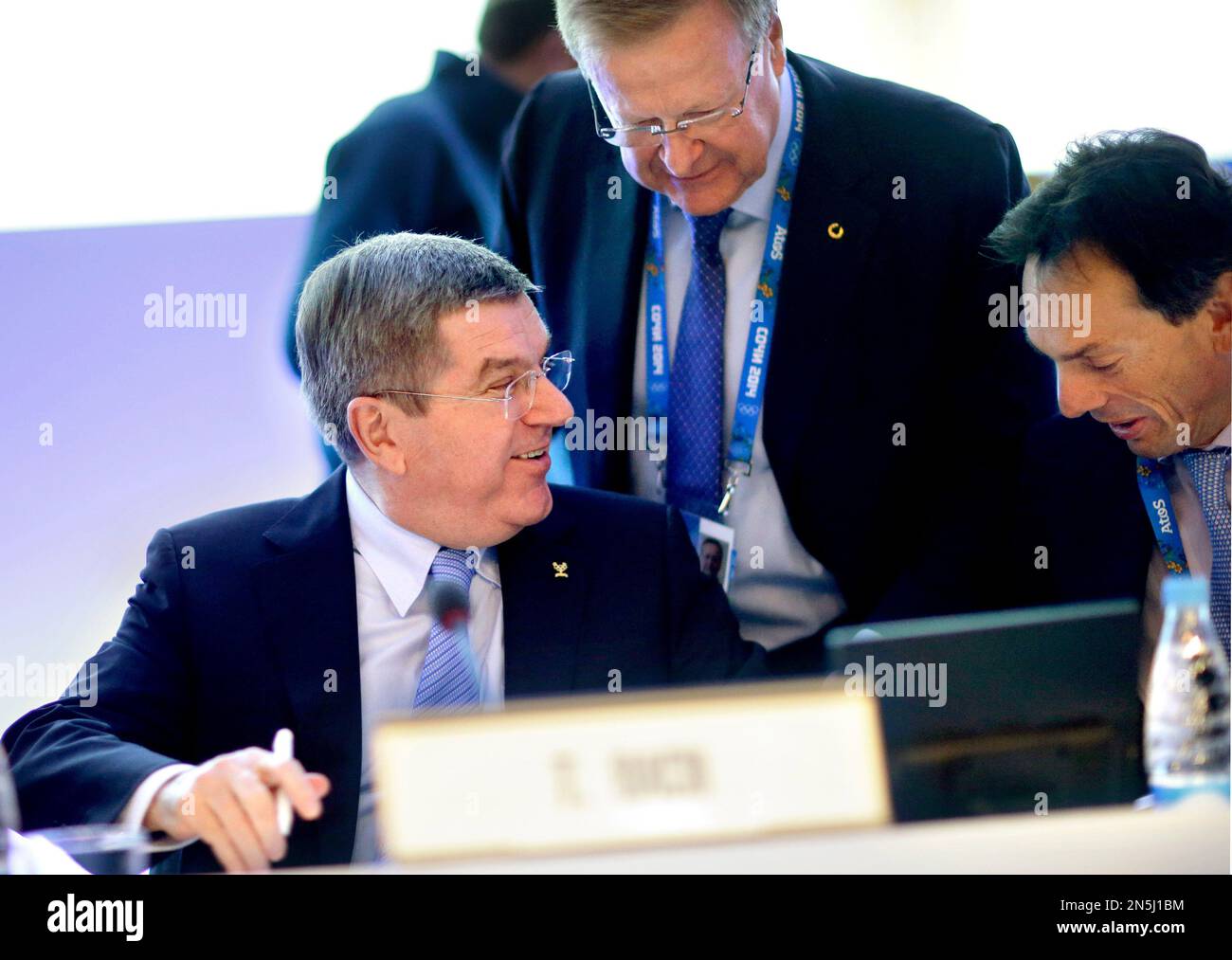 International Olympic Committee President Thomas Bach, left, talks with Director General Christophe De Kepper, right, and executive board member John Coates, prior to opening the IOC's general assembly at the 2014 Winter Olympics, Wednesday, Feb. 5, 2014, in Sochi, Russia. (AP Photo/David Goldman) Stockfoto
