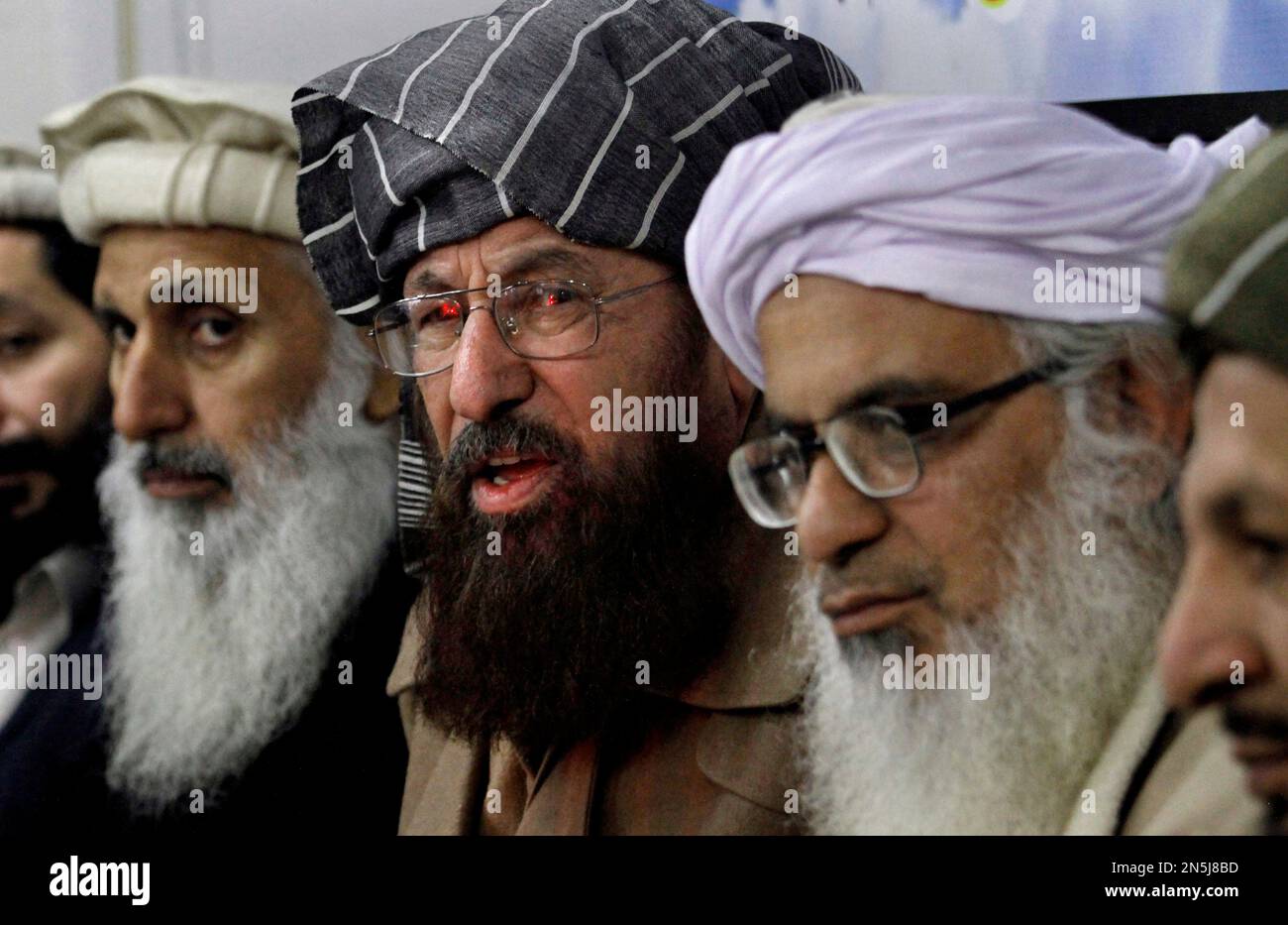 Pakistan's leading clerics, from left to right, Professor Ibrahim Khan, Maulana Sami-ul-Haq, and Maulana Abdul Aziz, listen to a reporter during a press conference in Islamabad, Pakistan, Monday, Feb. 3, 2014. The Pakistani Taliban wants five well-known political and religious figures including Khan, Haq and Aziz to represent them in peace talks with the government. according to a statement from the militant group Sunday. (AP Photo/Anjum Naveed) Stockfoto