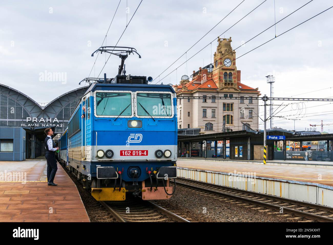 Elektrische Passagierlokomotive, am Bahnsteig am Prager Hauptbahnhof, mit dem Ticketsammler, der mit dem Zugfahrer spricht. Prag, Tschechisch Stockfoto