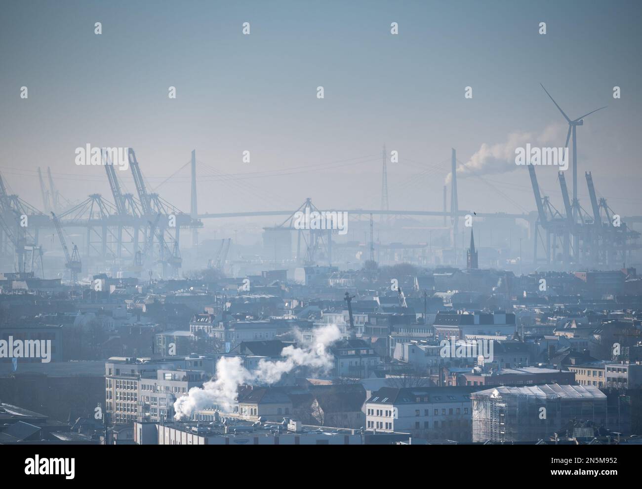 Kalter und nebiger Tag in Hamburg. Bild vom Stadtzentrum, Kraniche im Hafen und die Koehlbrandbrücke in der Ferne. Stockfoto