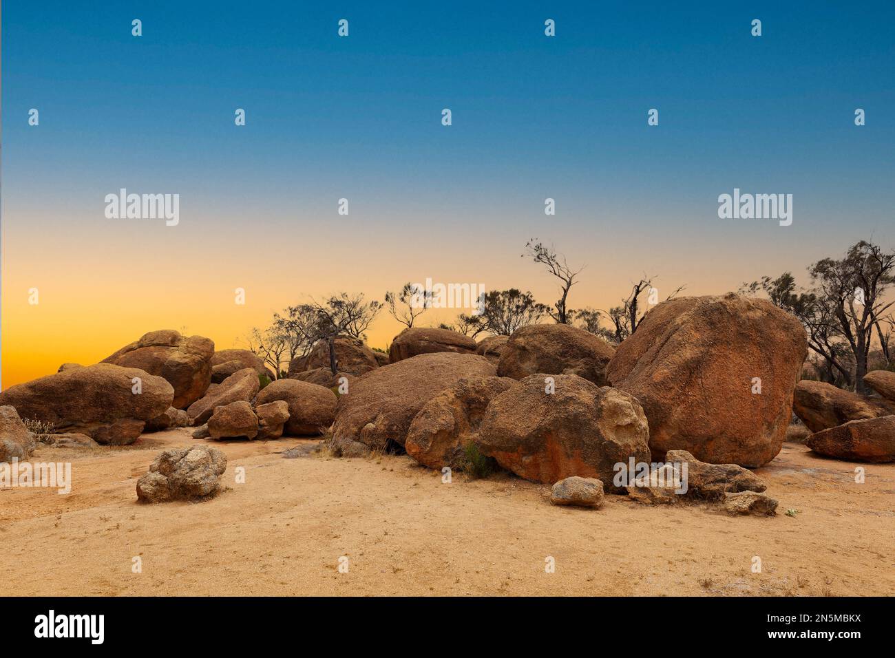 Landschaft bei Sonnenuntergang mit großen roten Felsbrocken auf dem Plateau über dem Wave Rock in der Nähe der Stadt Hyden in Westaustralien vor dem Hintergrund von Onkel Stockfoto