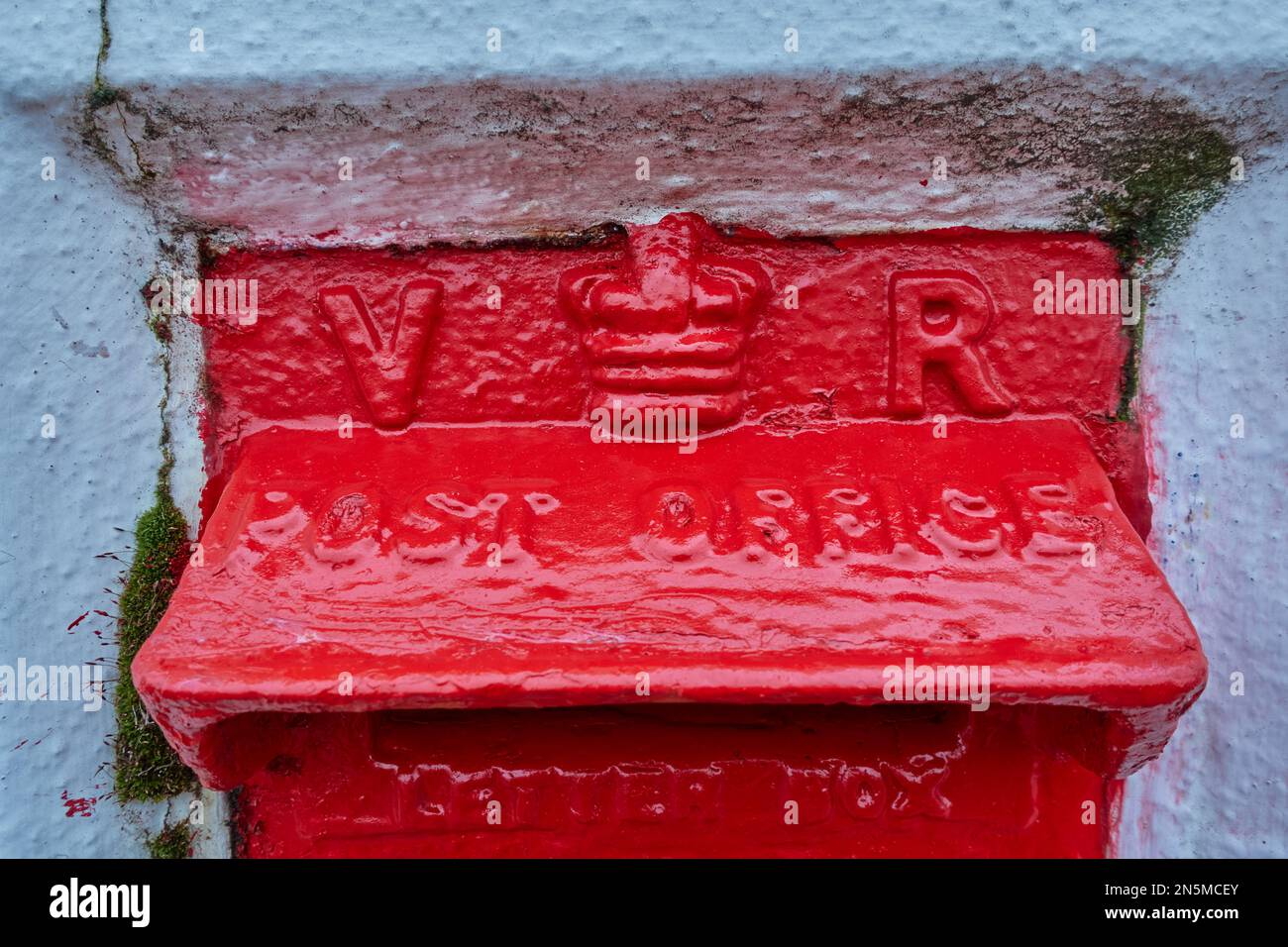 Ein roter britisch-viktorianischer Briefkasten in einer Wand. Stockfoto