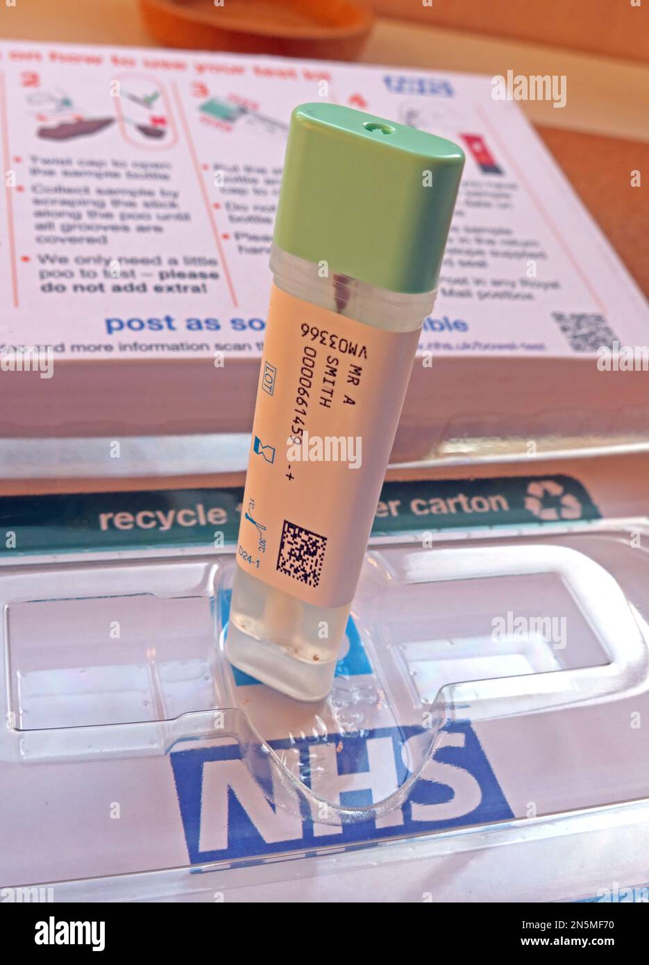 NHS-Darmkrebs-Screening-Programm, Pooprobe bereit zum Veröffentlichen, mit vorbezahltem, nachverfolgtem Royal Mail-Umschlag Stockfoto