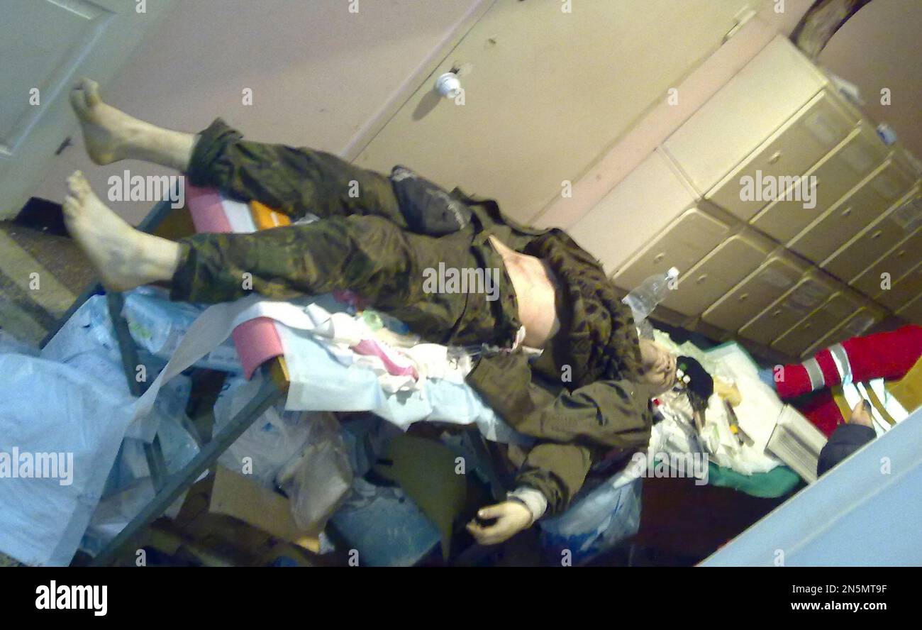 The body of an unidentified man lies in a building near the street where clashes took place in Kiev, Ukraine, on Wednesday, Jan. 22, 2014. Two people have died in clashes between protesters and police in the Ukrainian capital Wednesday, according to medics on the site, in a development that will likely escalate Ukraine's two month-long political crisis. (AP Photo/Yuras Karmanau) Stockfoto