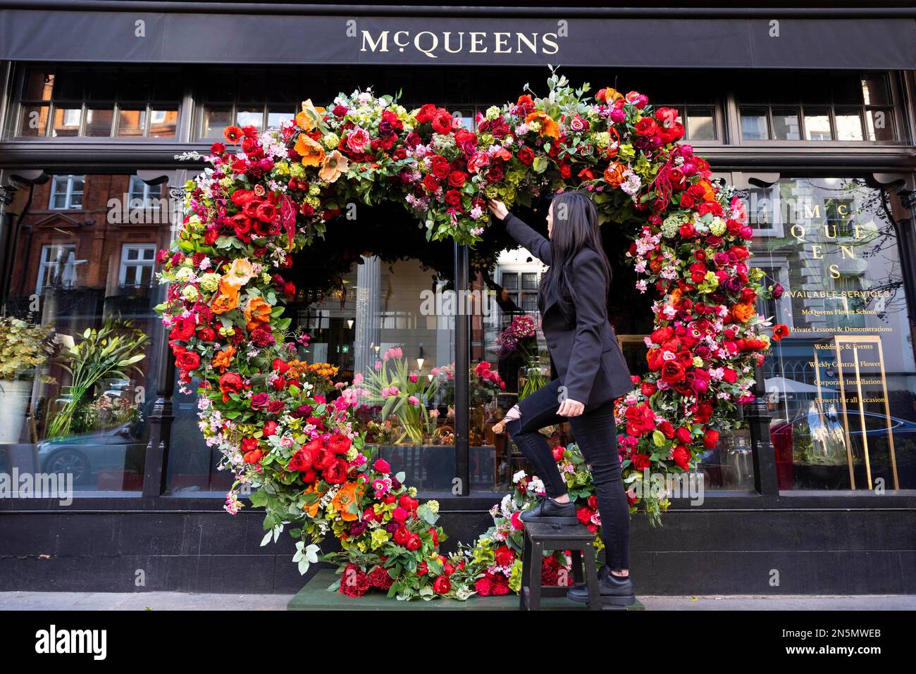 REDAKTIONELLE VERWENDUNG NUR Florist Kirstie Tompkins, der zur Feier des Valentinstages vor der McQueens Flower School in Mayfair ein neues, beeindruckendes Blumendesign mit dem letzten Schliff präsentiert. Foto: Donnerstag, 9. Februar 2023. Stockfoto