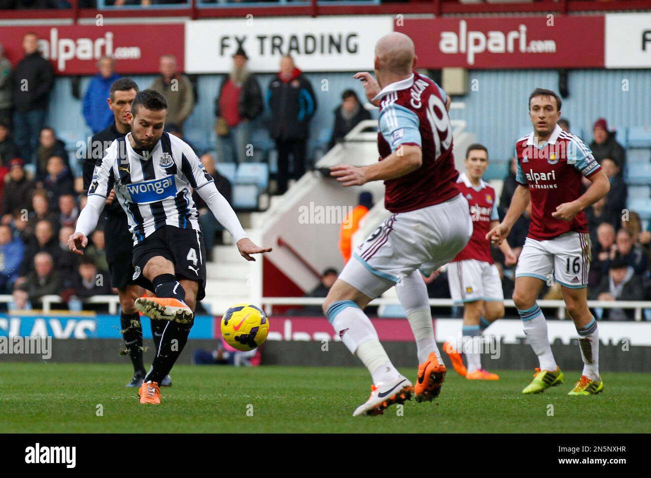 Newcastle United's Yohan Cabaye, left, shoots to score against West Ham United during their English Premier League soccer match at Upton Park, London, Saturday, Jan. 18, 2014. (AP Photo/Sang Tan) Stockfoto