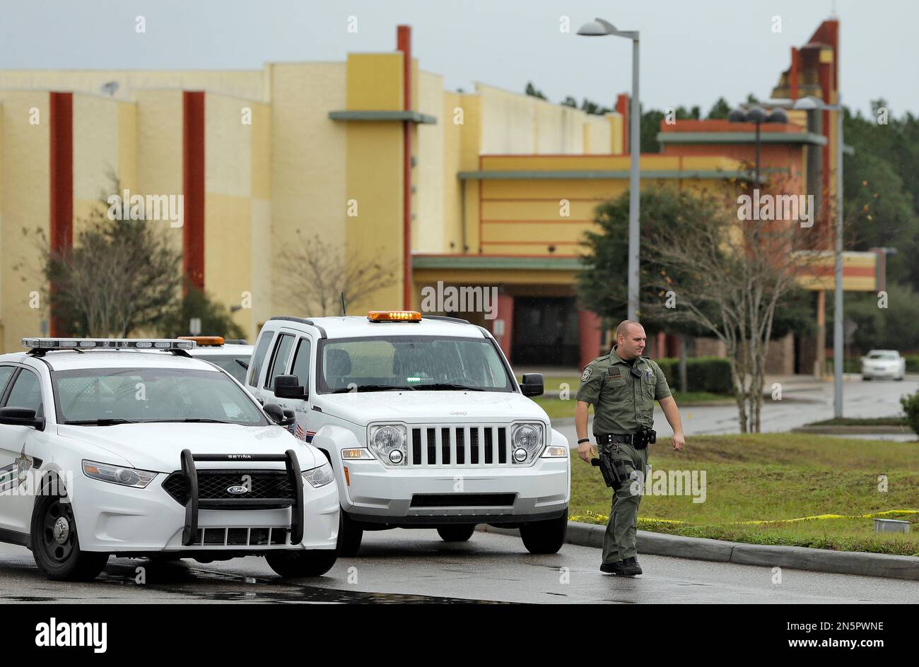 A Pasco County sheriff's deputy stands guard outside the driveway to ...
