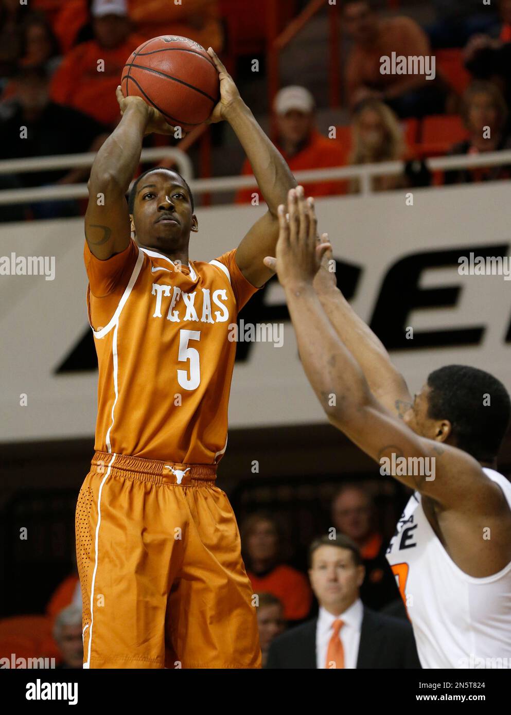 Texas guard Demarcus Holland (2) shoots over Oklahoma State guard Marcus Smart (33) in the first half of an NCAA college basketball game in Stillwater, Okla., Wednesday, Jan. 8, 2014. (AP Photo/Sue Ogrocki) Stockfoto