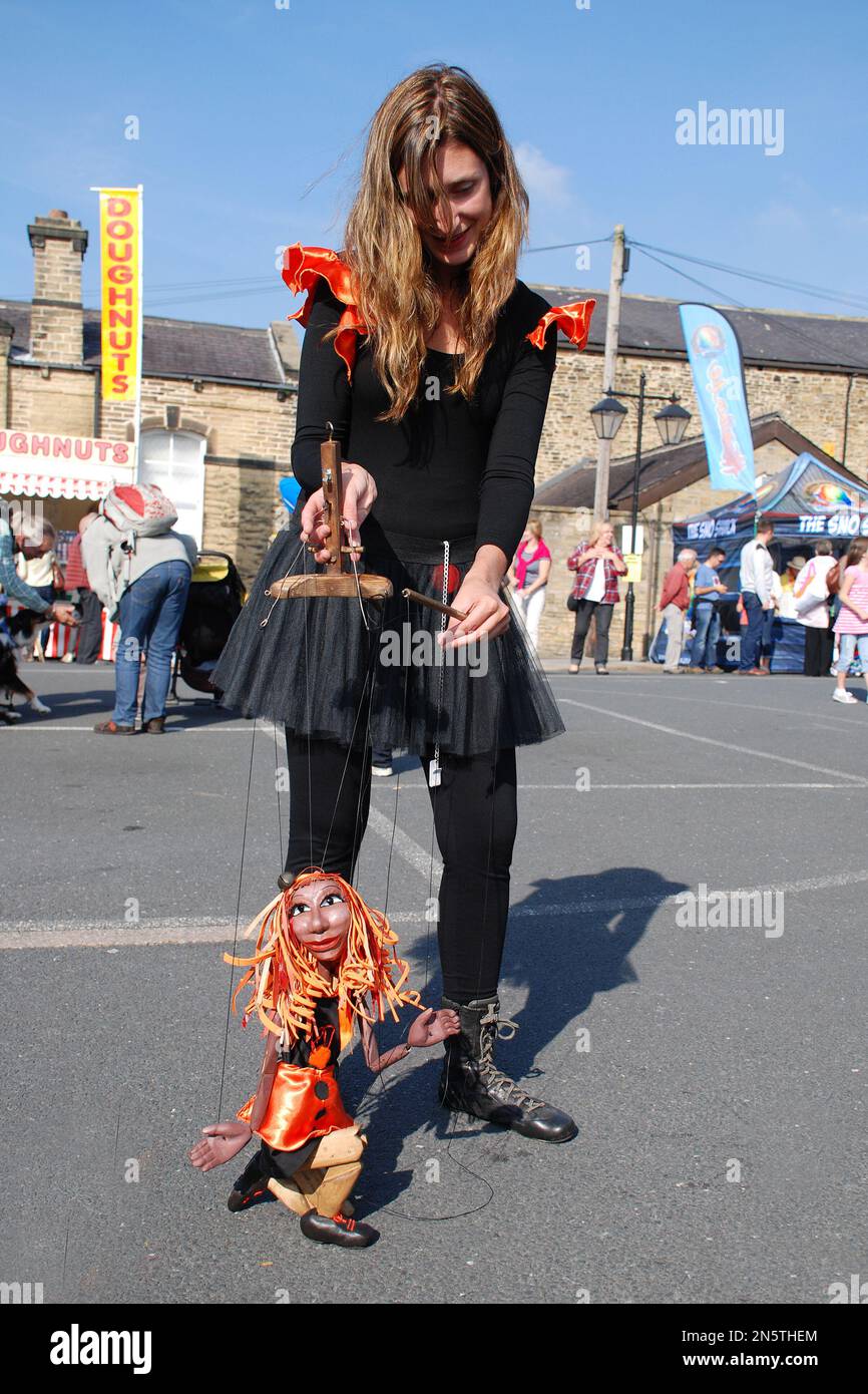 Der Puppenspieler unterhält die Kinder beim Skipton Puppet Festival und erweckt die Illusion, dass die Puppe lebt. Stockfoto