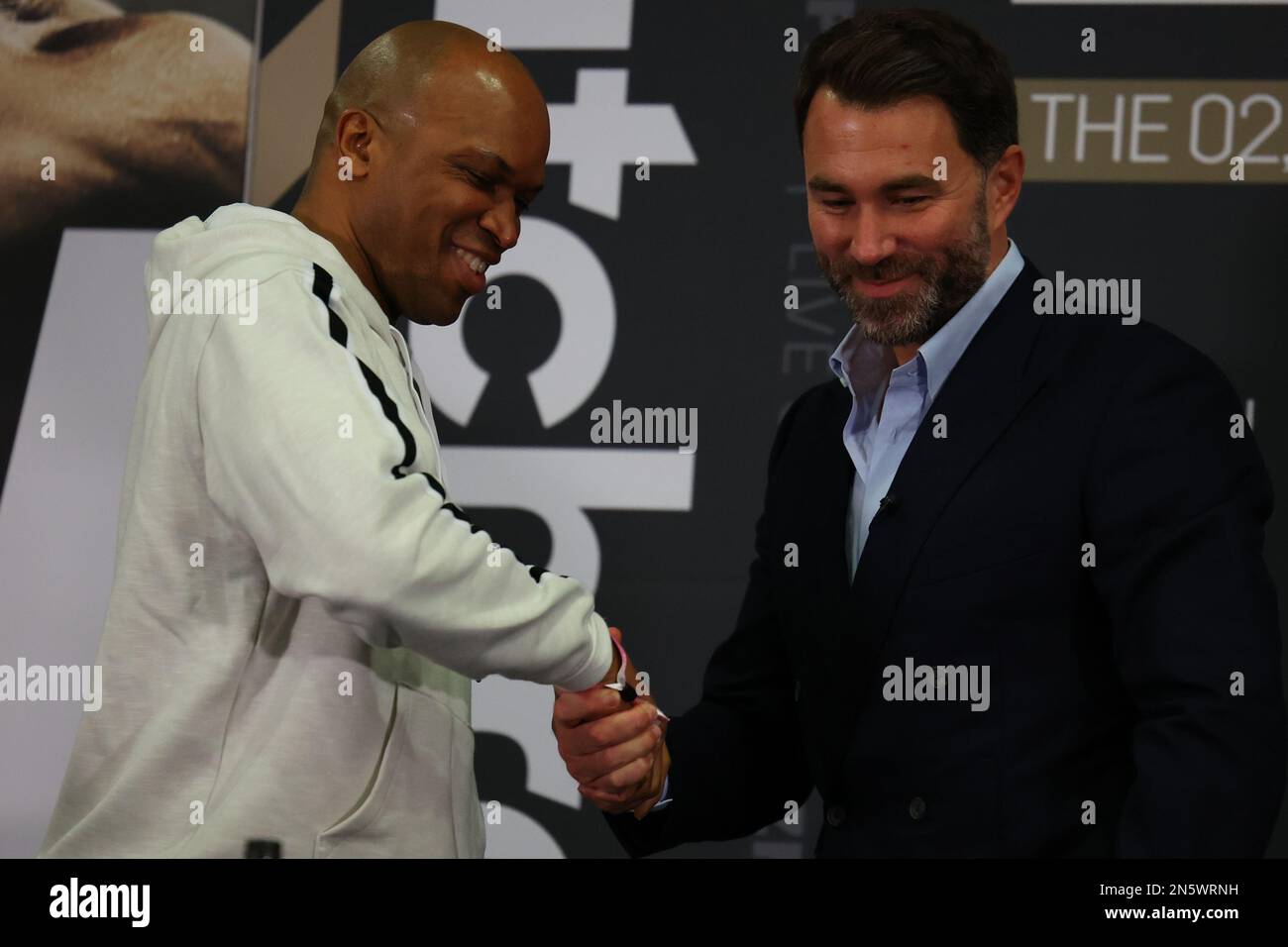 9. Februar 2023, Hilton London Syon Park, London, England; 2023 Anthony Joshua versus Jermaine Franklin Press Conference; Eddie Hearn schüttelt sich die Hand mit Trainer Derrick James Stockfoto