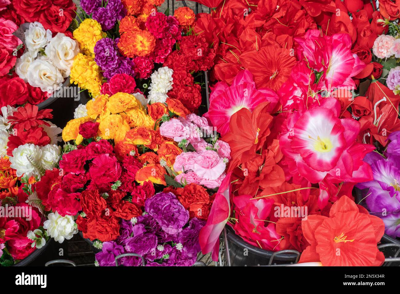 Farbenfrohe künstliche Blumen vor dem Laden Stockfoto