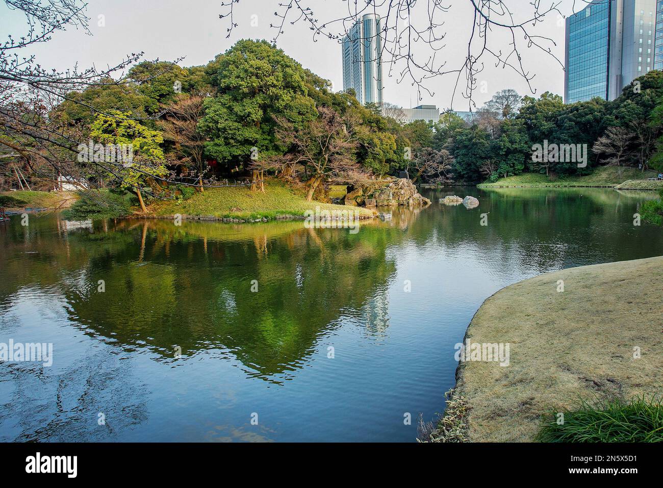 Künstliche Insel im Teich des Koishikawa Korakuen Gartens und Reflexion