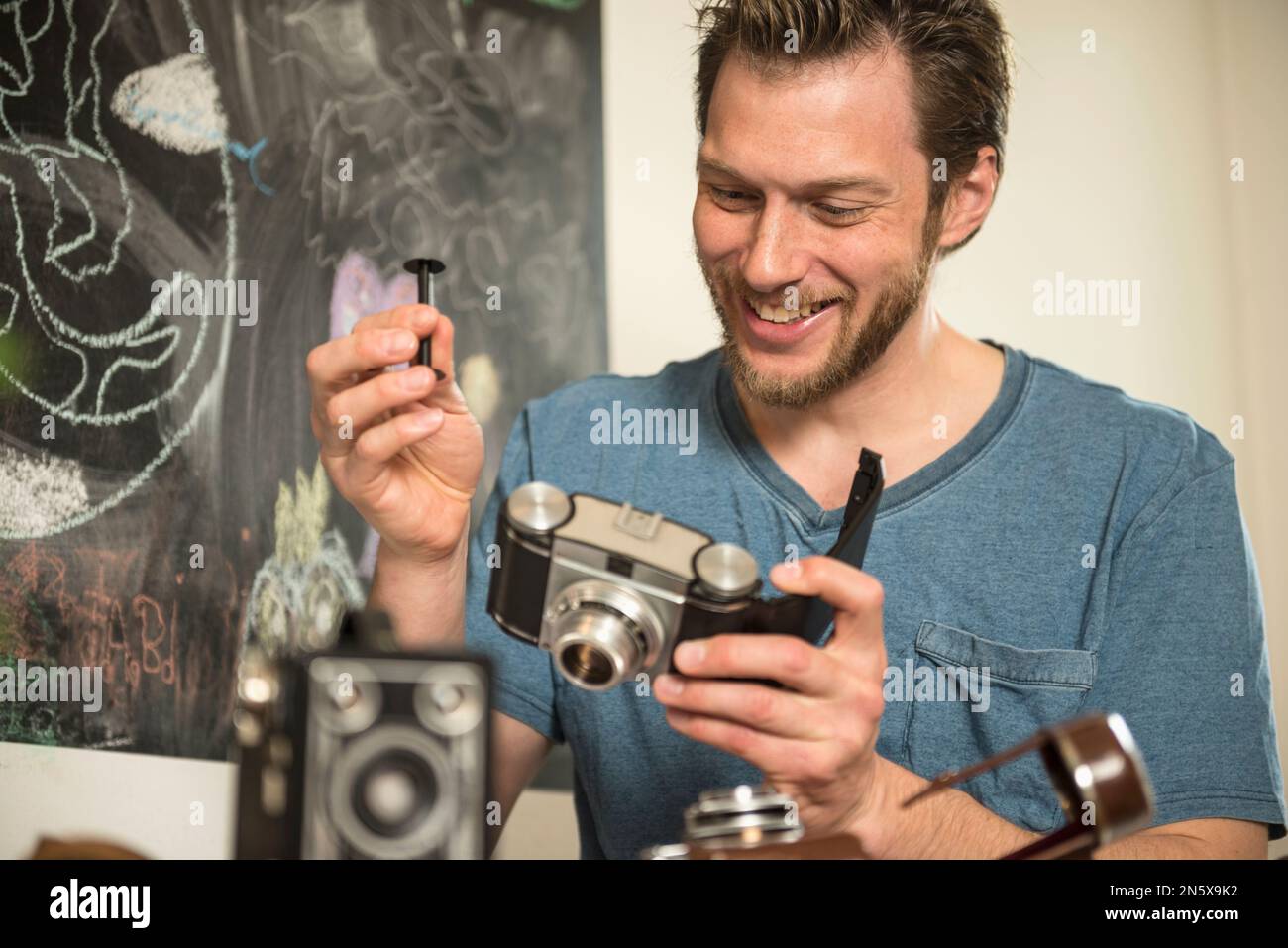Mann repariert antike Kamera im Speisesaal, München, Bayern, Deutschland Stockfoto