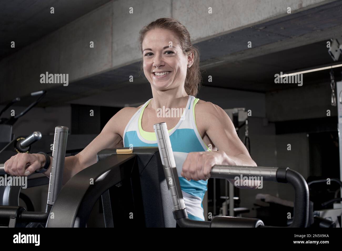 Porträt einer mittelerwachsenen Frau, die auf einem Trainingsgerät in Bayern trainiert Stockfoto