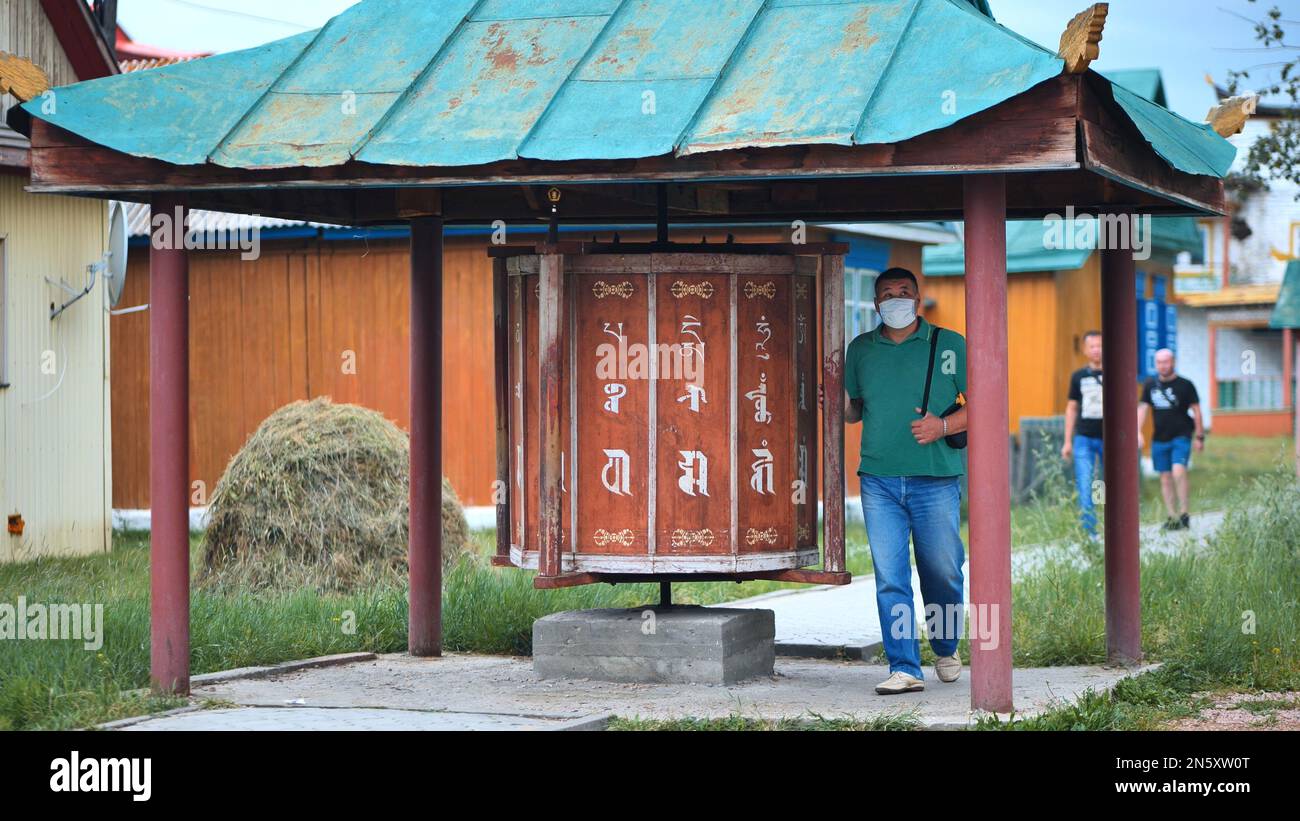 Verkhnyaya Ivolga, Burjatien, Russland - 9. August 2021: Pilger drehen eine Gebetstrommel in einem buddhistischen Tempel. Ivolginsky Datsan ist das Zentrum der Stockfoto