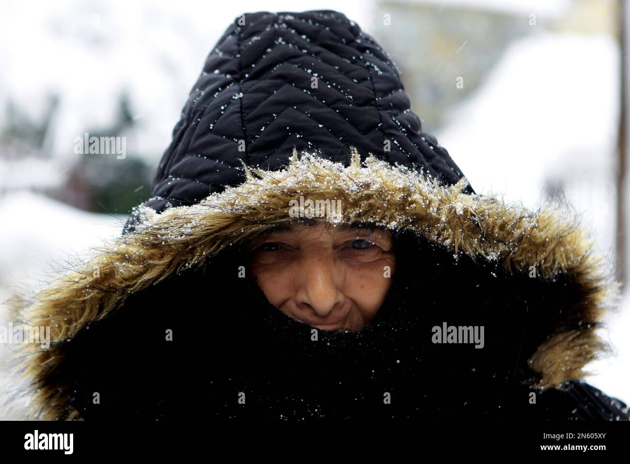 Yianoulla Mourouzi, 65, is seen after 3 days of heavy snow at her village of Palaichori in the Nicosia suburbs, on the Troodos Mountain Friday, Dec. 13, 2013. Almost 40 mountain villages remain cut off due to heavy snowfall, while all roads leading to the peak of the island’s Troodos mountain range remains closed for all vehicles. Power outages in some areas has been restored, Cyprus Electricity Authority spokesman Costas Gavrielides said. The cold spell hit the island midweek and brought lots of snow in mountainous areas as temperatures dropped some 11 degrees Celsius lower than seasonal norm Stockfoto