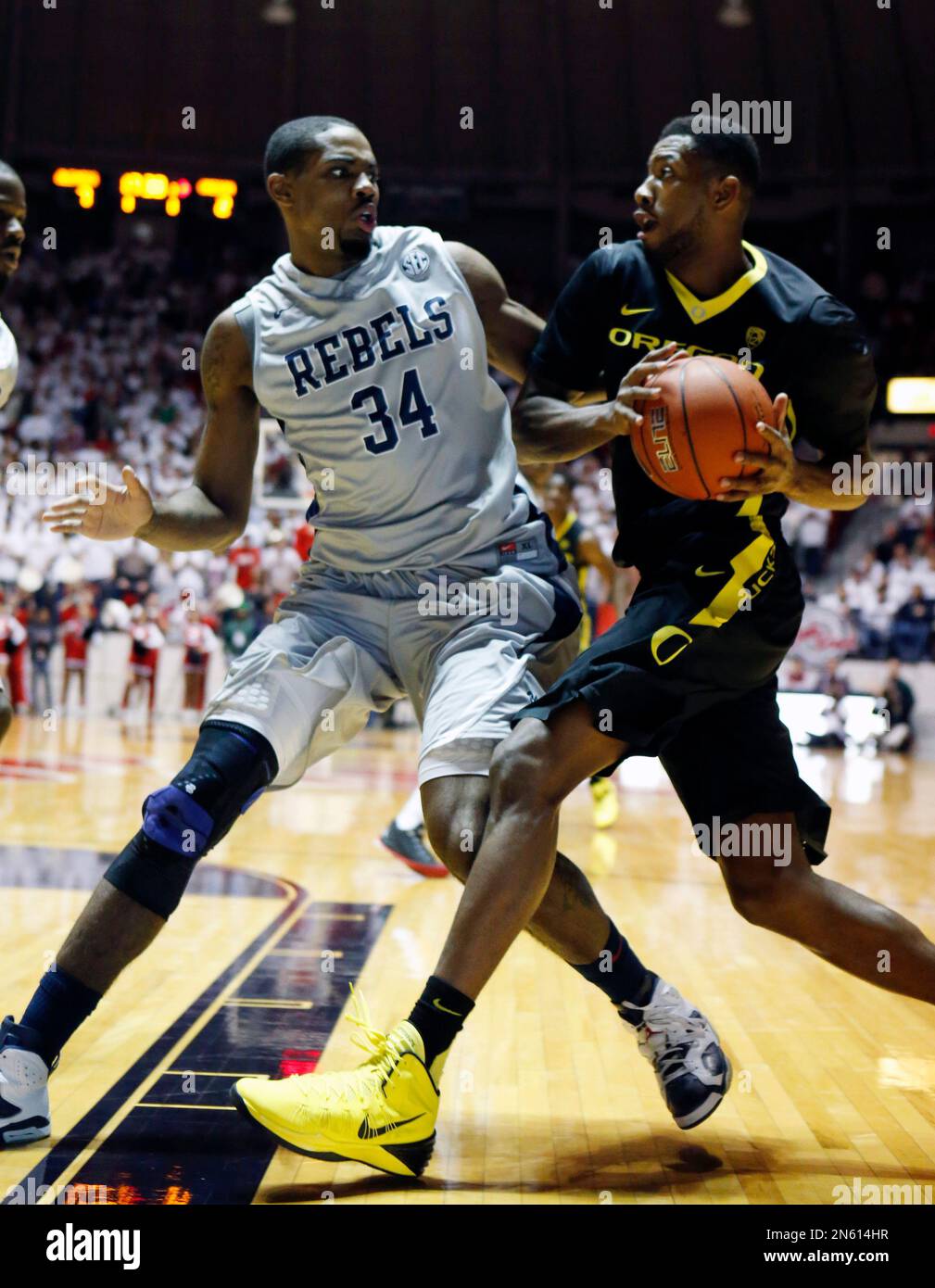 Oregon forward Mike Moser tries to pass around Mississippi forward Aaron Jones (34) in the first half of an NCAA college basketball game in Oxford, Miss., Sunday, Dec. 8, 2013. (AP Photo/Rogelio V. Solis) Stockfoto