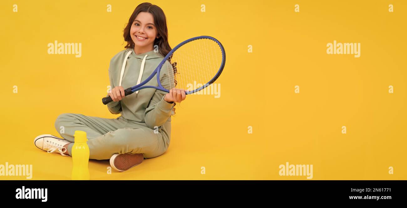 Kind sitzen mit Schläger und Wasserflasche. Kind mit Tennisschläger. Teenager-Mädchen nach dem Sporttraining. Horizontales Poster mit isoliertem Kindergesicht, Banner Stockfoto