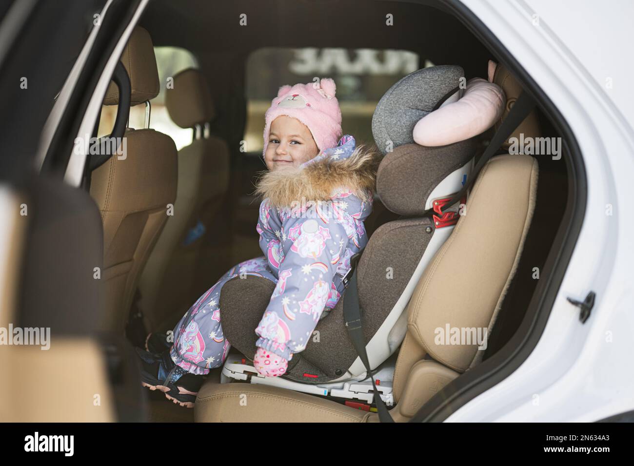 Ein Baby in der Sonnenbrille seiner Mutter sitzt in einem Auto in einem  Kindersitz und zeigt seine Zunge aus dem Fenster Stockfotografie - Alamy