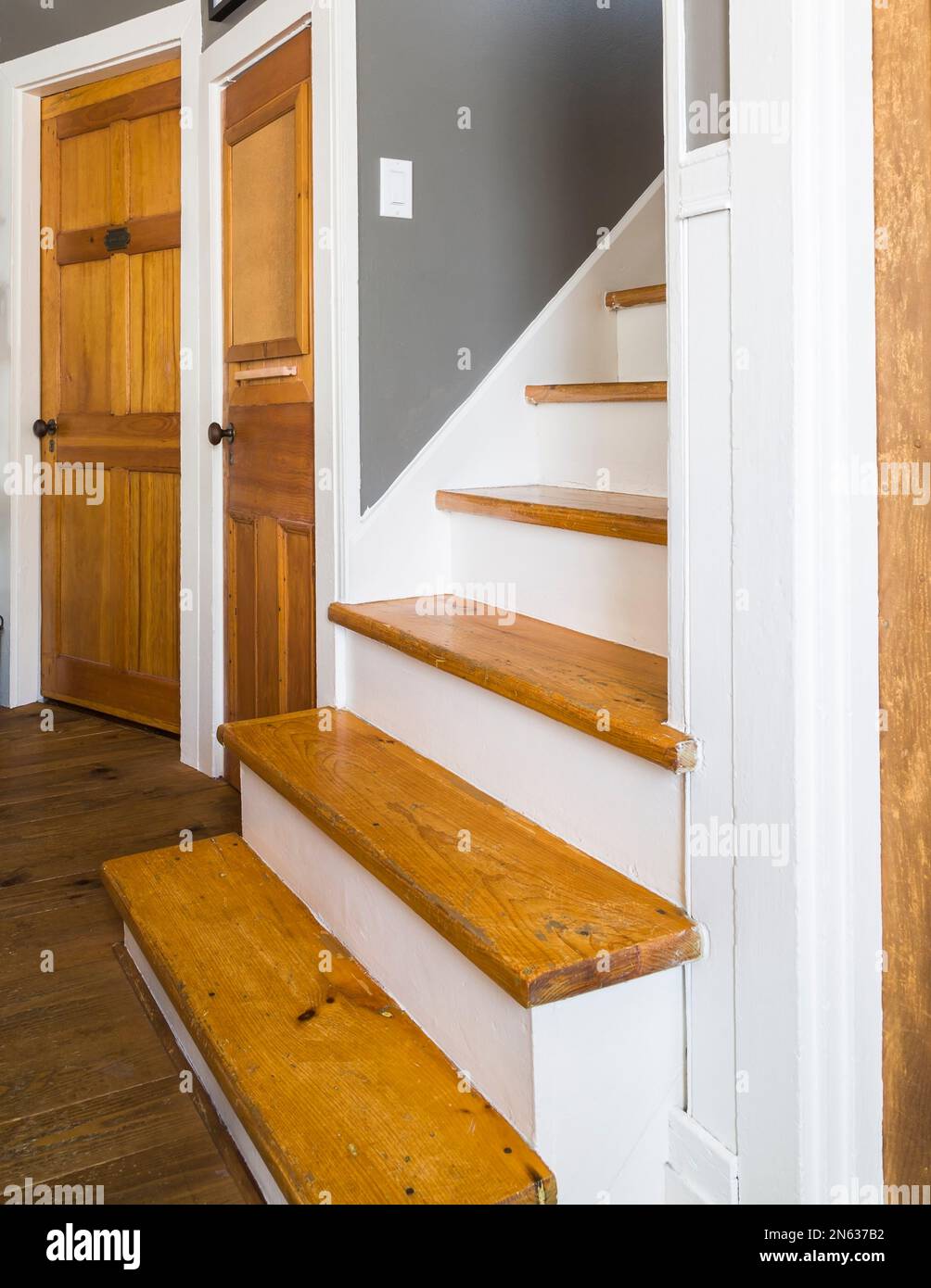 Eine Pinienholztreppe führt zum oberen Stockwerk in einem alten Haus im 1839-Kanadiana-Cottage-Stil. Stockfoto