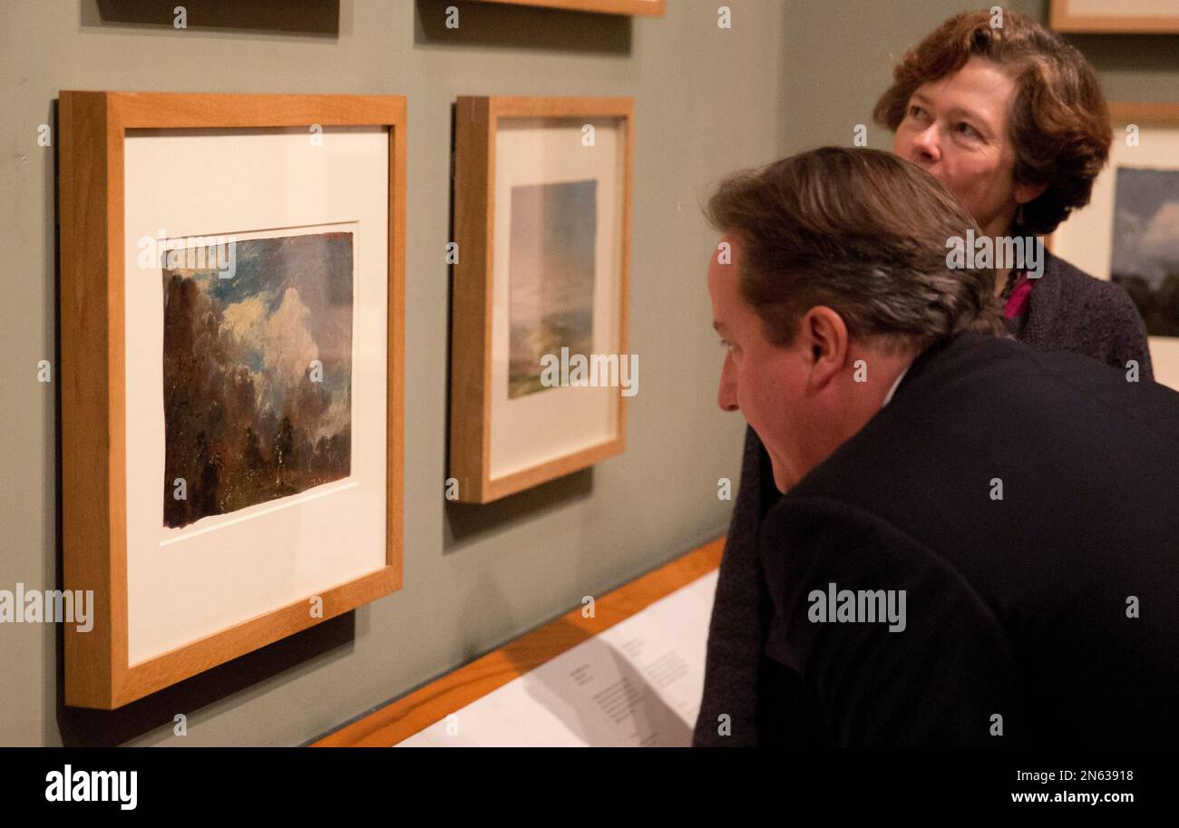 British Prime Minister David Cameron is shown the newly discovered previously unknown oil sketch painting by John Constable entitled "Landscape with a Kiln", at left, from 1821 or 1822 by Head Painting Conservator Nicola Costaras, right, as an additional part of his visit to the "Masterpieces of Chinese Painting: 700-1900" at the Victoria & Albert Museum in London, Thursday, Nov. 28, 2013. The museum said it was discovered when conservators attempted to remove the lining on the back of "Branch Hill Pond: Hampstead", another work by the English romantic painter known for his landscapes, while p Stockfoto