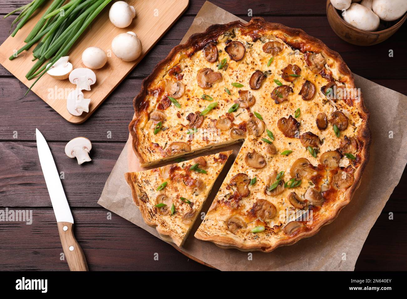 Köstlicher Kuchen mit Pilzen und Käse auf einem braunen Holztisch Stockfoto