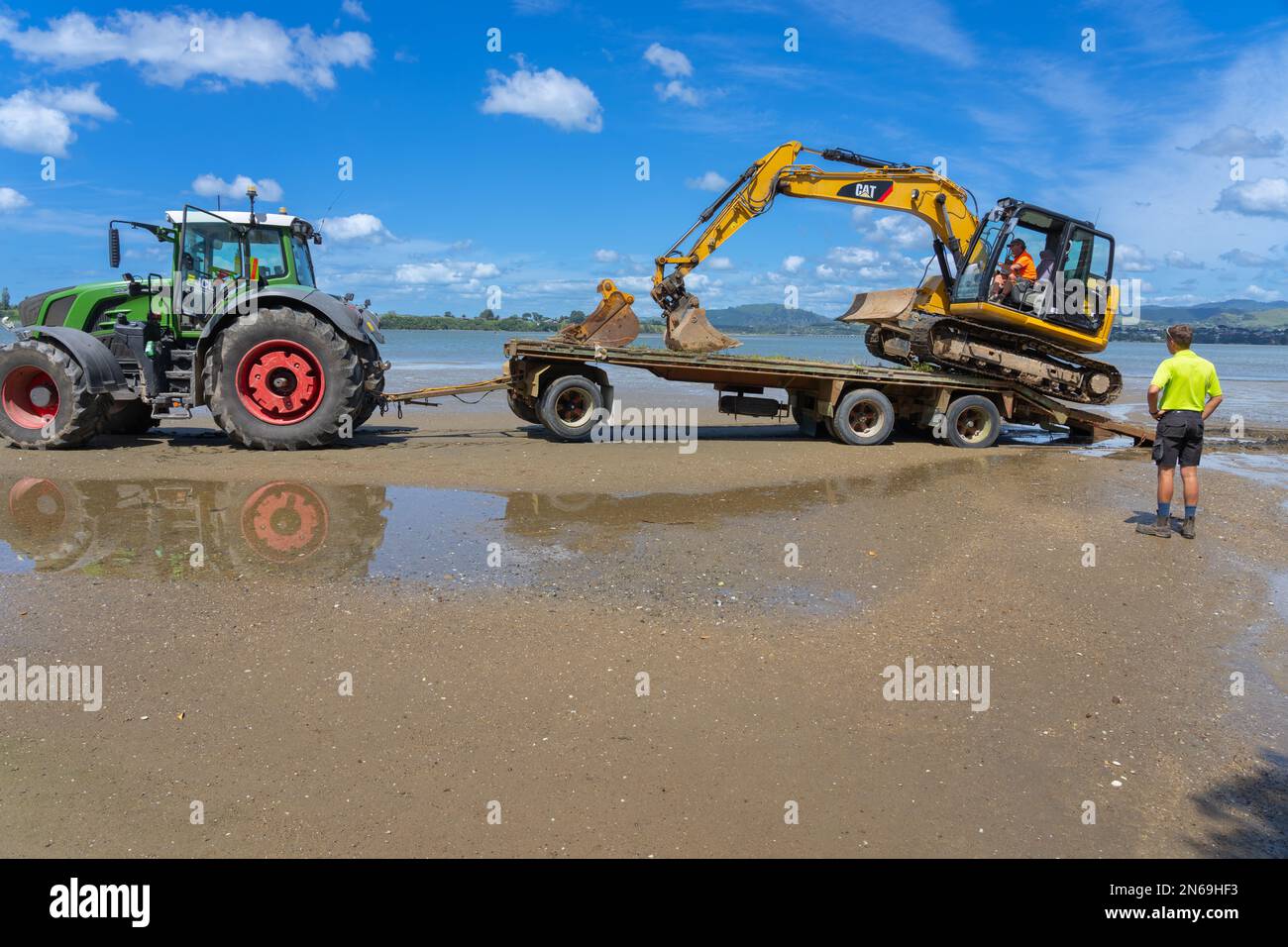 Tauranga Neuseeland - Februar 8 2023: Graber am Anhänger hinter dem Traktor am Strand. Stockfoto