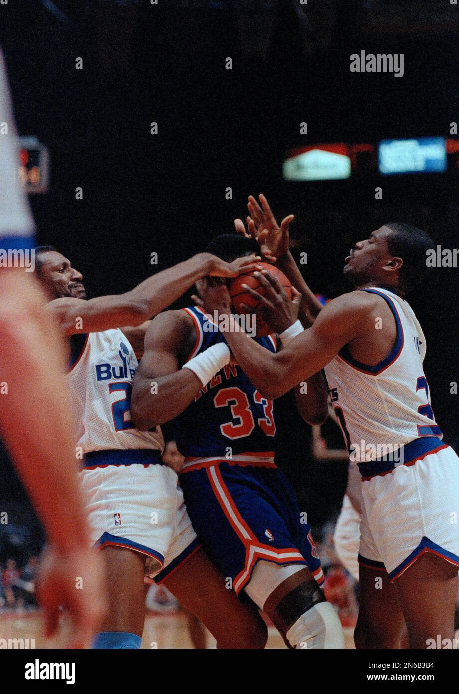 New York Knicks center Patrick Ewing, center, gets squeezed in by Washington Bullets forward Charles Jones, left, and forward Bernard King during the fourth quarter at the Capital Center in Landover, Md., Feb. 23, 1990. (AP Photo/Edwin Remsberg) Stockfoto