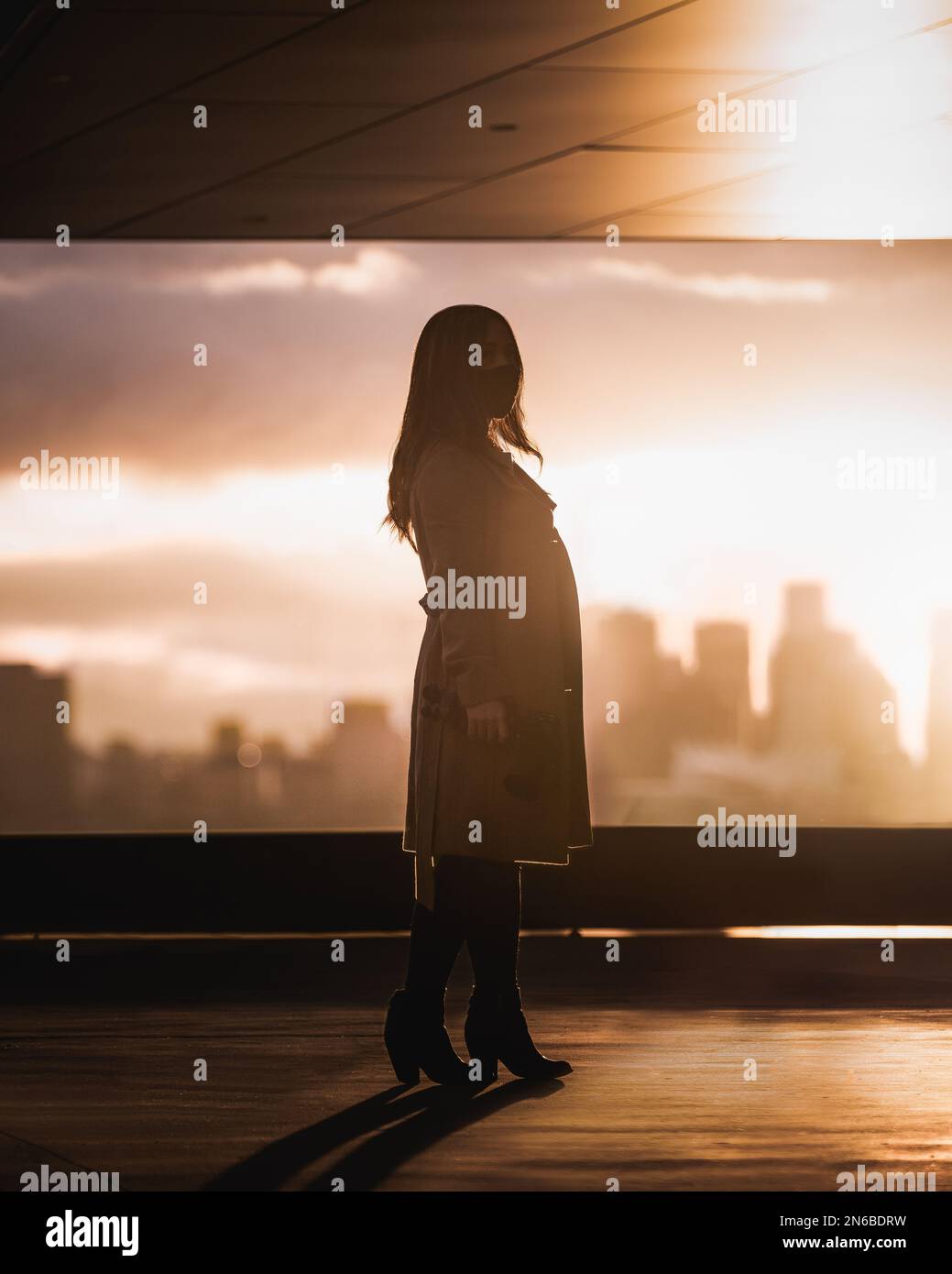 Sonnensilhouette eines Mädchens in einer Stadt Stockfoto