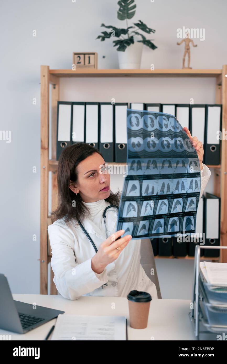 Der Arzt untersucht die MRT-Untersuchung des Brustkorbs und des Halses des Patienten in den Händen. Instrumentelle Krankheitsdiagnostik, Konzeptfoto. Speicherplatz kopieren Stockfoto