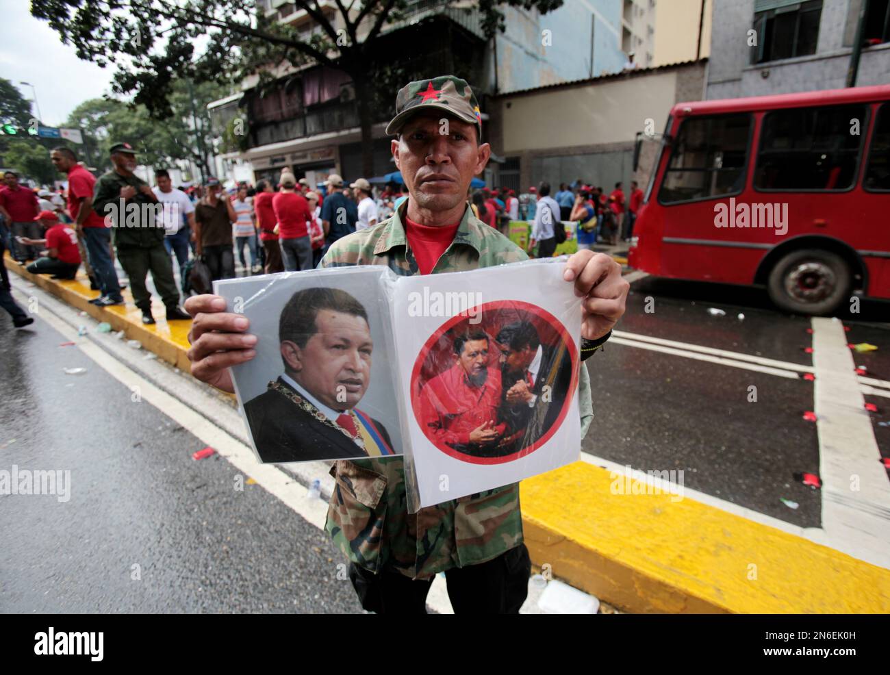 A street vendor hawks images of the late President Hugo Chavez during an event commemorating the one-year anniversary of Chavez's re-election, outside Miraflores Palace in Caracas, Venezuela, Monday, Oct. 7, 2013. Chavez, who had been re-elected to a third presidential, died in March 2013 at age 58 after at two-year battle with cancer. (AP Photo/Fernando Llano) Stockfoto