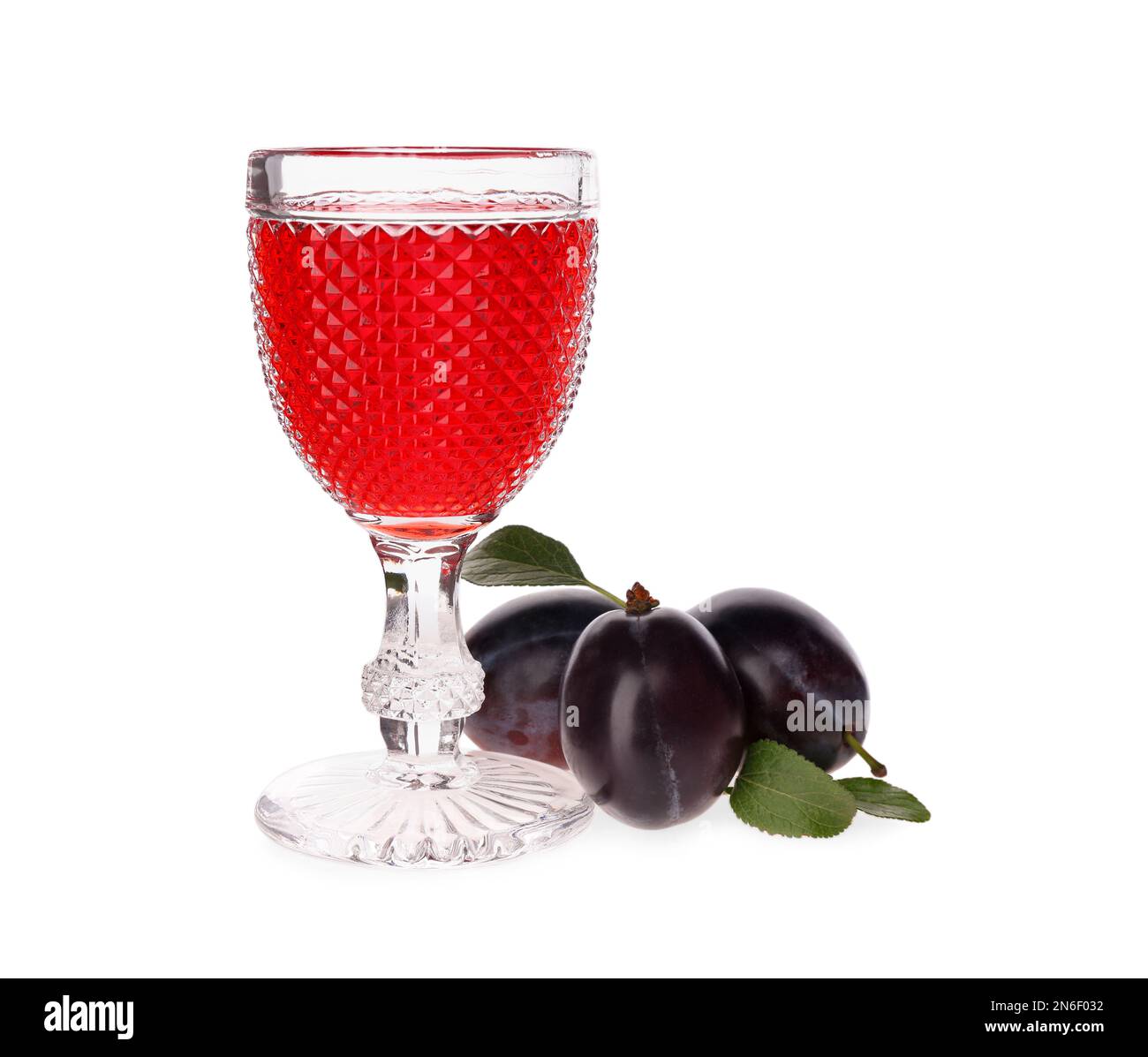 Köstlicher Pflaumenlikör und reife Früchte auf weißem Hintergrund. Hausgemachtes, starkes alkoholisches Getränk Stockfoto