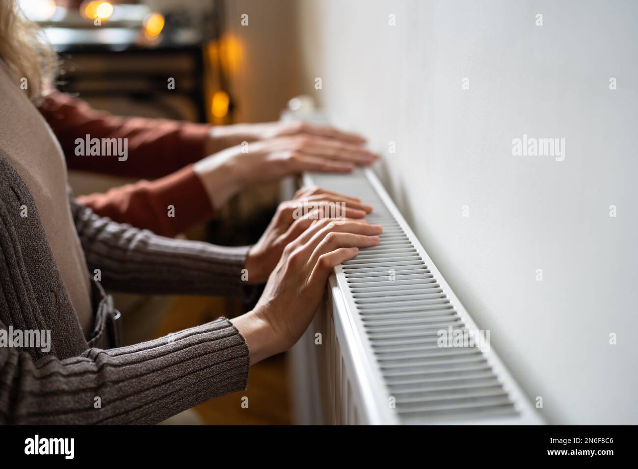 Familienpaar Hausbesitzer, die die Kühlerheizung mit den Händen berühren, um sich auf die Temperaturen im Gefrierpunkt vorzubereiten Stockfoto