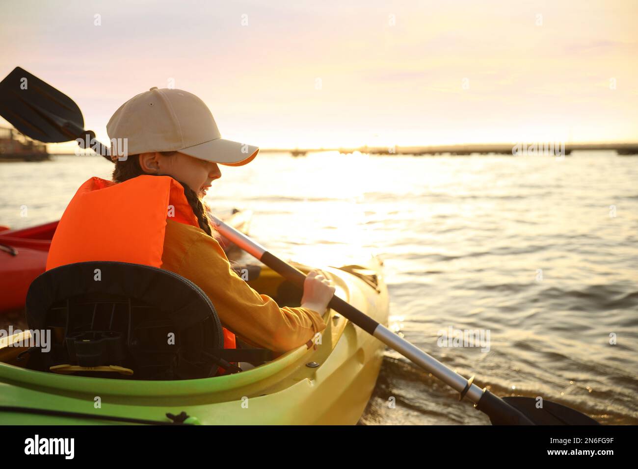 Glückliches Mädchen, Kajakfahren auf dem Fluss. Aktivitäten im Ferienlager Stockfoto