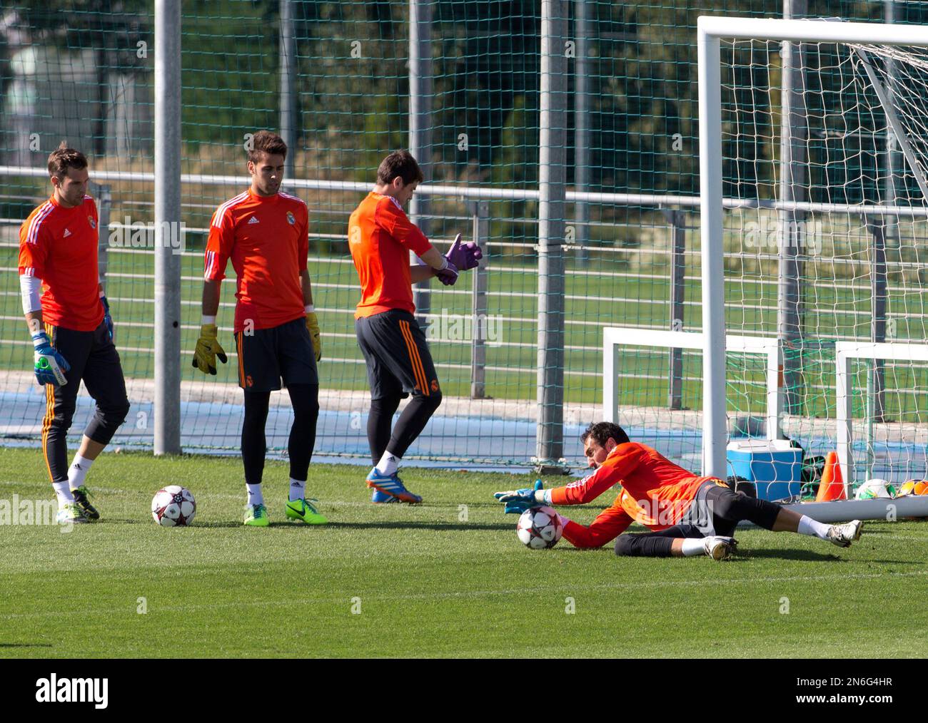 Real Madrid goalkeeper Iker Casillas, third left, adjusts his gloves as team mate and fellow goalkeeper Diego Lopez, right makes a save during a training session in Madrid, Spain Tuesday Oct. 1, 2013. Real Madrid will play FC Copenhagen Wednesday in a Group B Champions League soccer match. (AP Photo/Paul White) Stockfoto