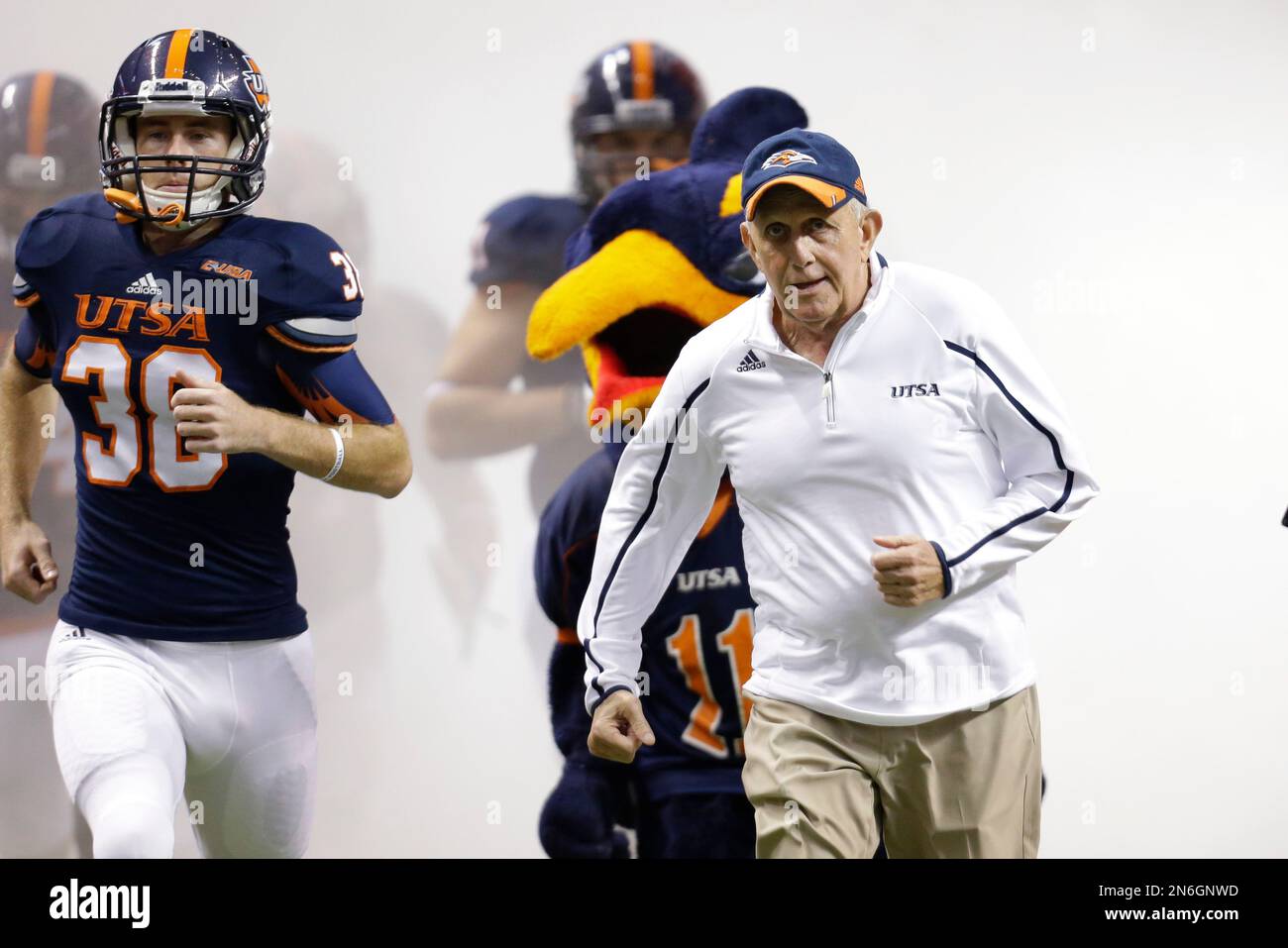 Texas San Antonio coach Larry Coker, right, runs onto the field with his team prior to an NCAA college football game, Saturday, Sept. 28, 2013, in San Antonio. (AP Photo/Eric Gay) Stockfoto