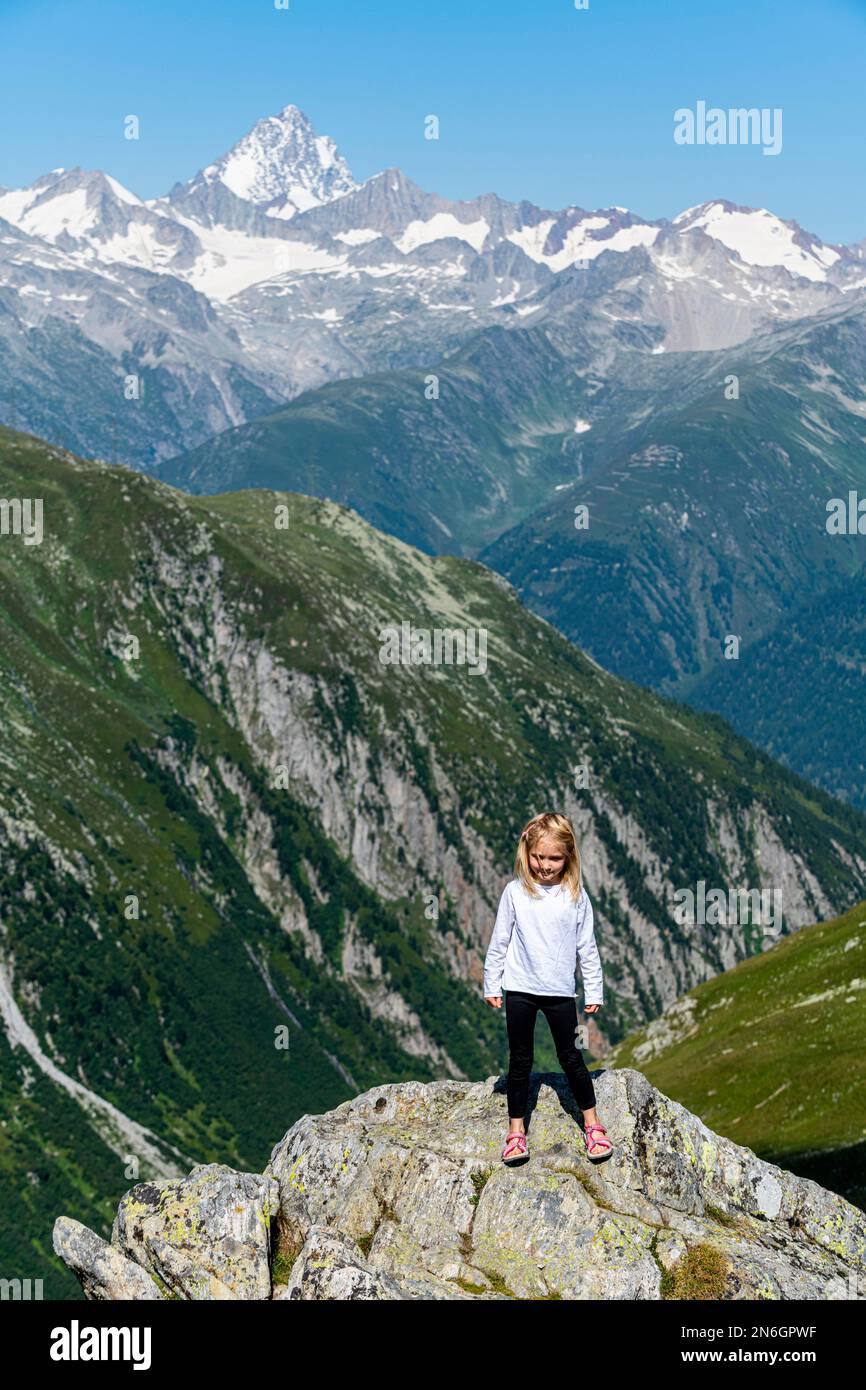 Junge Frau, die vor den Schweizer Alpen posiert, Nufenen-Pass, Schweiz Stockfoto
