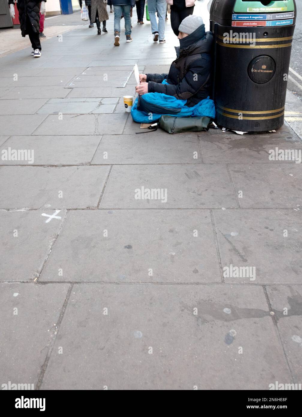 London, England, Großbritannien. Ein Obdachloser sitzt auf dem Bürgersteig in der Oxford Street Stockfoto