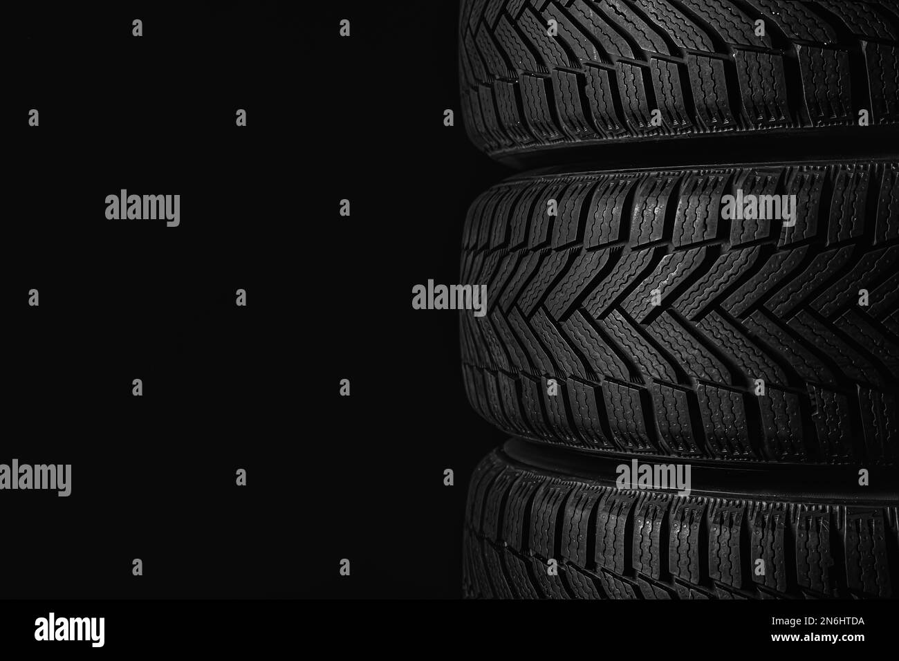 Winterreifen auf schwarzem Hintergrund, Nahaufnahme. Platz für Text Stockfoto