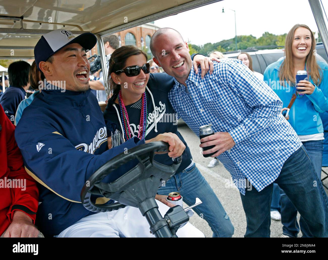 Milwaukee Brewers' Norichika Aoki drives a golf cart and poses for pictures in the parking lot before the baseball game against the St. Louis Cardinals on Saturday, Sept. 21, 2013, in Milwaukee. Players surprised tailgaters as part of fan appreciation night. (AP Photo/Jeffrey Phelps) Stockfoto
