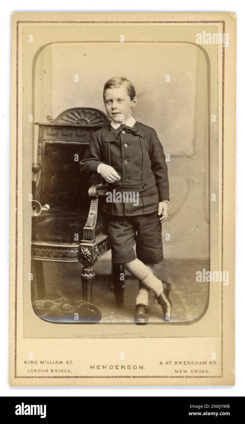 Original viktorianische Ära CDV (Carte de Visite oder Visitenkarte) in Emaille entspanntes Studioporträt eines jungen viktorianischen Jungen im Alter von 5 Jahren und 7 Monaten, genannt Frity Short, trägt einen Anzug, aus dem Studio A. L. Henderson, London, Großbritannien, datiert 1879. Stockfoto