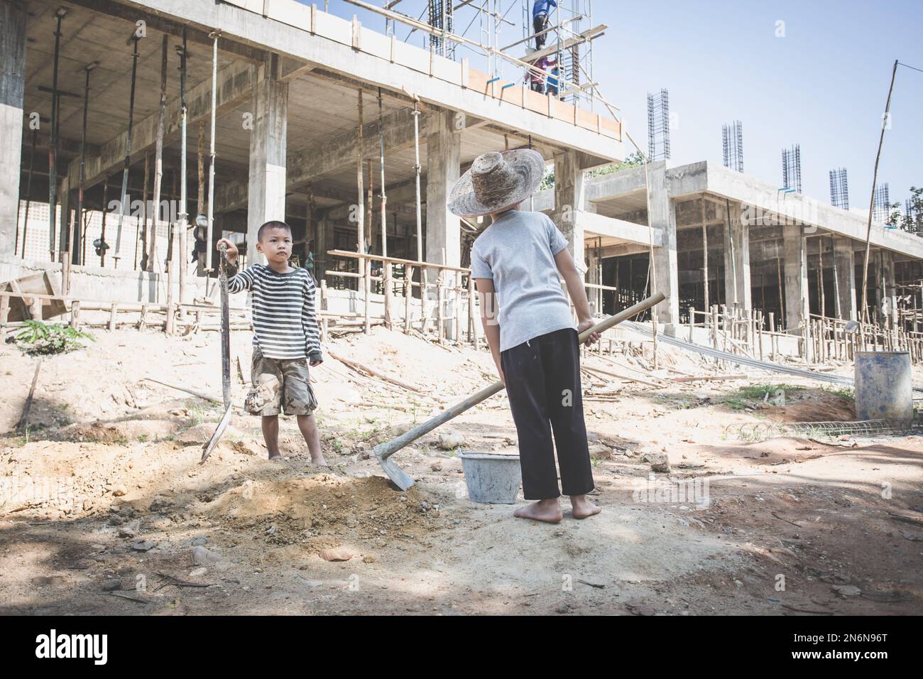 Kinder, die hart auf der Baustelle arbeiten, Kinderarbeit, Welttag gegen Kinderarbeit Konzept. Stockfoto
