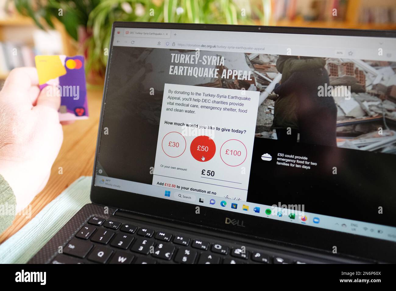 Hereford UK – Freitag, 10. Februar 2023 – Mann mit Debitkarte beim Surfen im Disaster Emergency Committee ( DEC ) Aufruf für Spenden zur Unterstützung der Opfer der jüngsten Erdbeben in der Türkei und Syrien. Foto Steven May/Alamy Live News Stockfoto