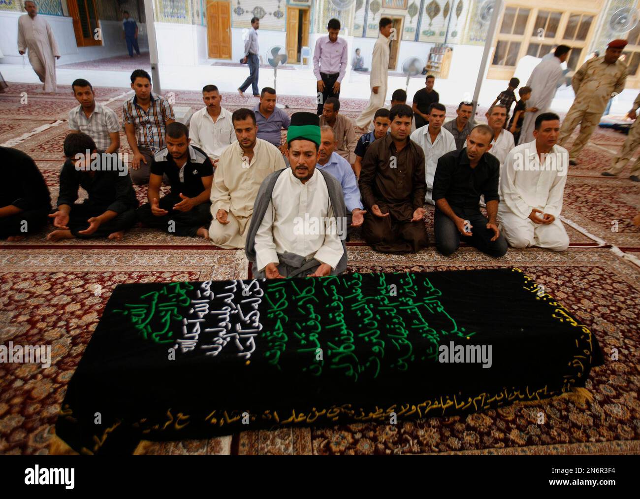 Mourners pray over the coffin of a man killed in a car bomb attack during the funeral in the Shiite holy city of Najaf, 100 miles (160 kilometers) south of Baghdad, Iraq, Wednesday, Sept. 4, 2013. The killings come amid a spike in deadly violence in recent months as insurgents try to capitalize on rising sectarian and ethnic tensions. The scale of the bloodshed has risen to levels not seen since 2008, a time when Iraq was pulling back from the brink of civil war. (AP Photo) Stockfoto