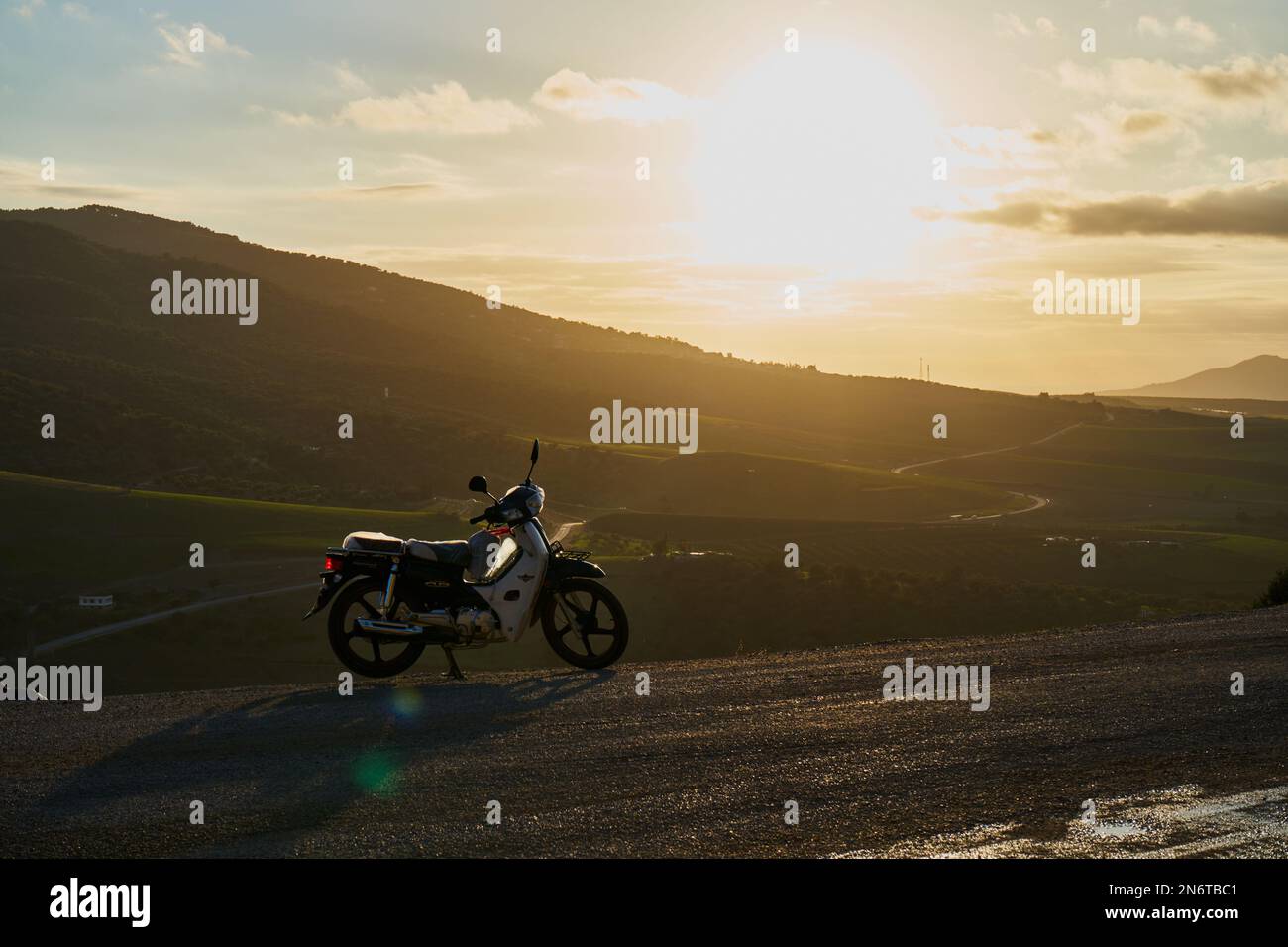 Eine Motorradsilhouette auf einer Bergstraße Stockfoto