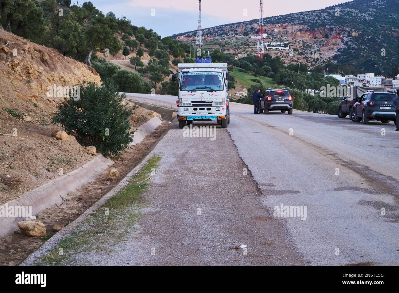 LKW und Auto auf einer Bergstraße geparkt Stockfoto