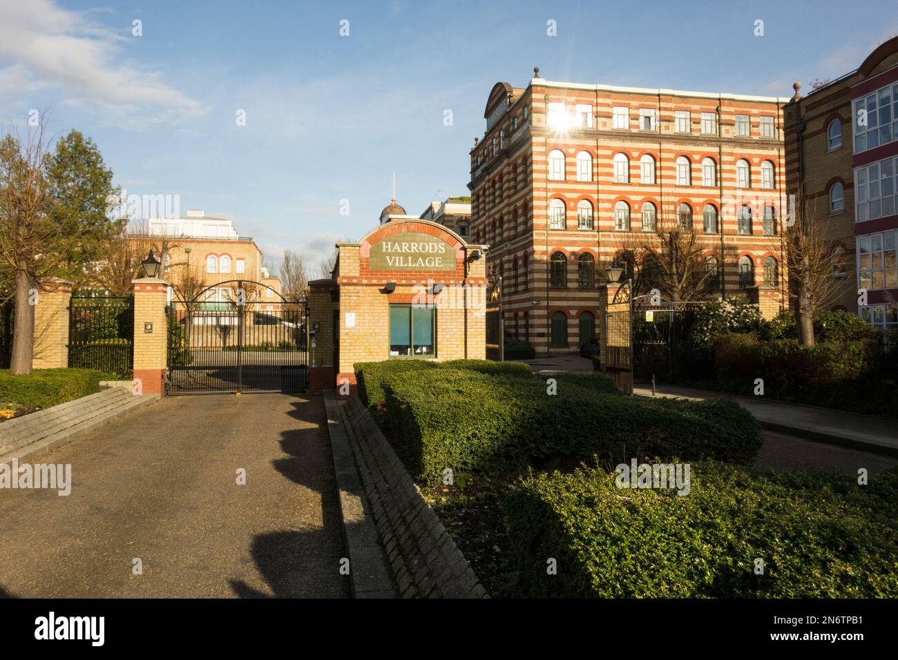 Der Eingang zu einer umzäunten Anlage in Harrods Village, Barnes, London, SW13, England, UK Stockfoto
