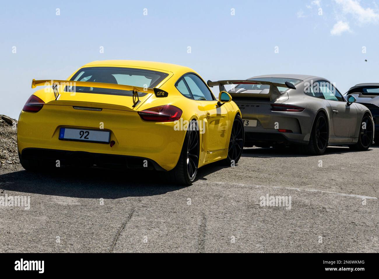 Vorne Sportwagen gelber Porsche Cayman GT4 mit Heckflügel Spoiler dahinter Porsche 911 GT3 mit Heckspoiler, Cime de la Bonette, Alpen, Frankreich Stockfoto
