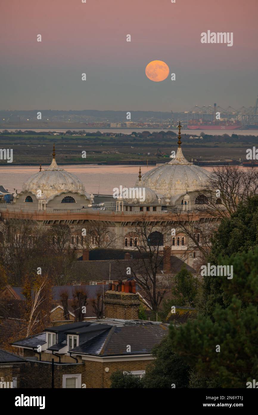 Der Vollmond erhebt sich über dem DP World London Gateway Port mit dem Siri Guru Nanak Darbar Gurdwara in Gravesend vom Windmühlen-Hügel. Stockfoto