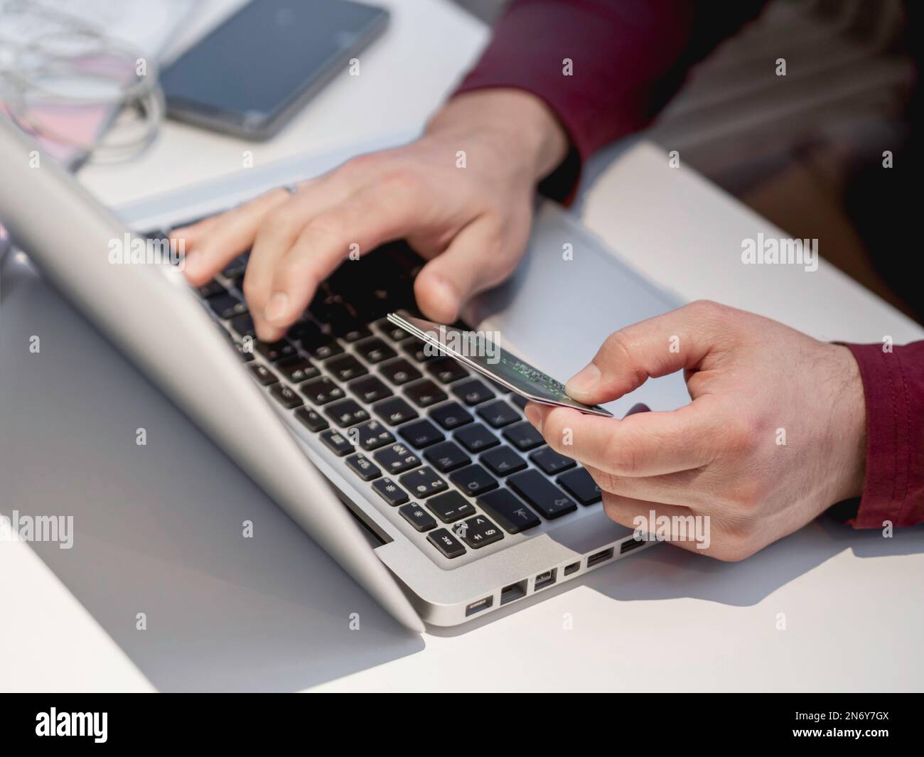 Mann verwendet Laptop, um für Online-Bestellung per Kreditkarte zu bezahlen. Online-Shopping oder E-Commerce. Kontaktloses Bezahlen durch drahtlose Technologien. Stockfoto